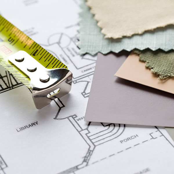 Tape measure next to plans and fabrics